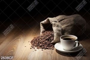 Tranh tách coffee đen cạnh bao cà phê đổ trên bàn