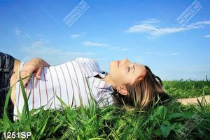Tranh cô gái trẻ nằm thư giãn trên thảm cỏ xanh